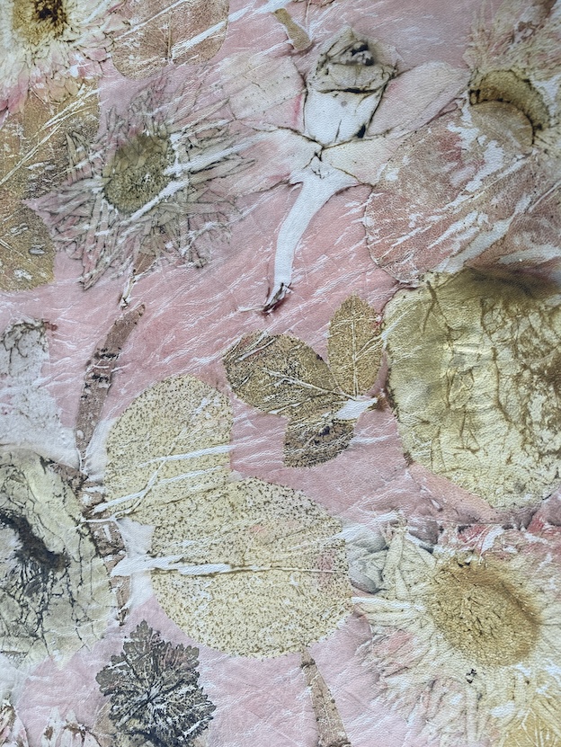Een artistieke weergave van gedroogde bloemen en bladeren op een roze achtergrond, met een variëteit aan natuurlijke texturen en kleuren.